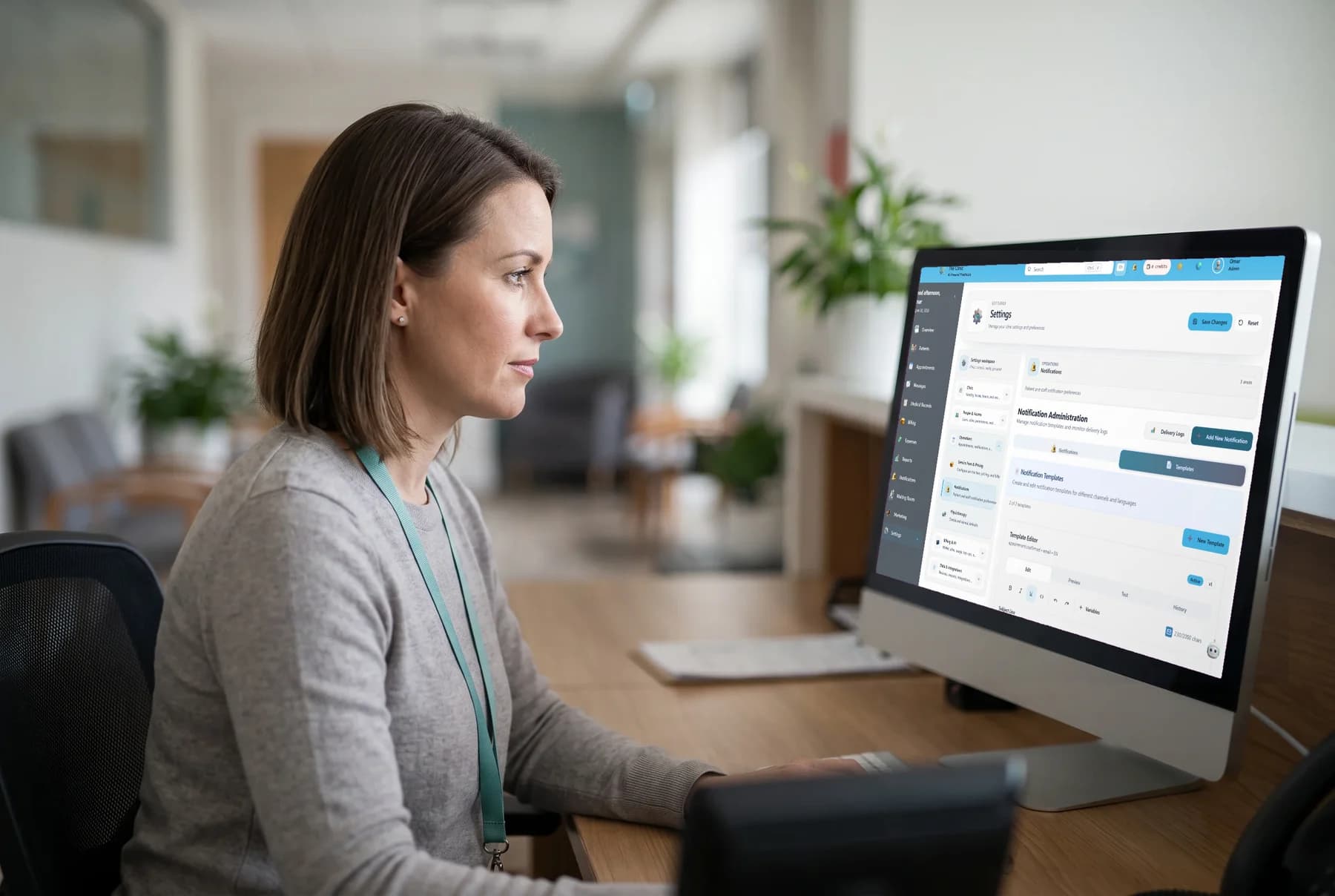 A practice manager reviewing a notification template in the clinic's front office.